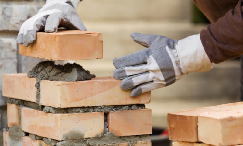 A tradesman laying bricks