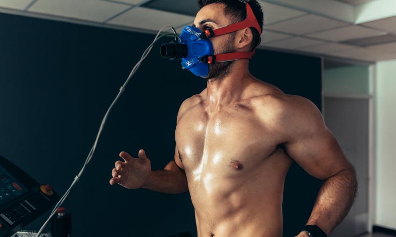 An athlete running on a treatmill with a breathing apparatus 
