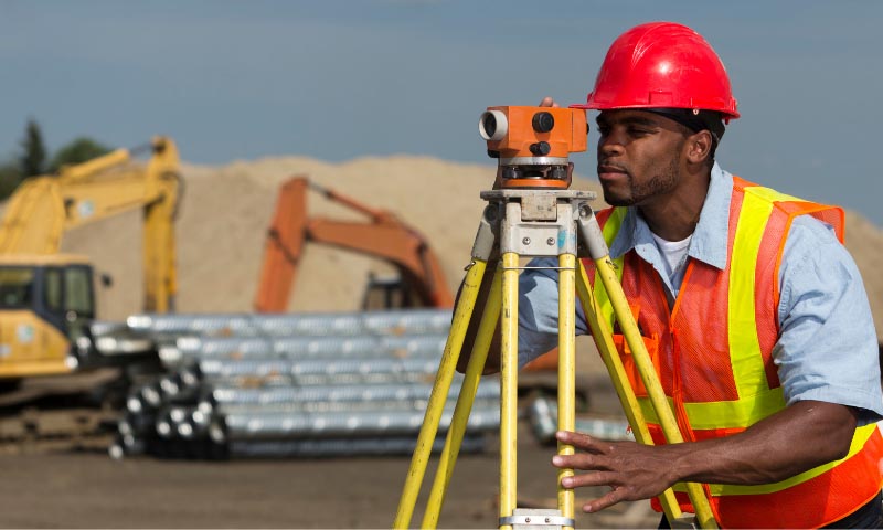 A construction student using surveying equipment